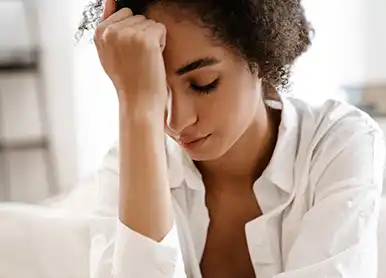 Individual at a table using a notebook , with a laptop placed next to them