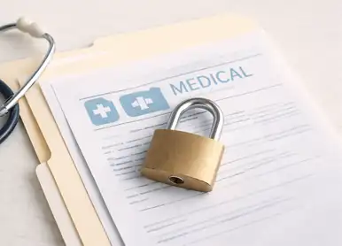 Individual at a table using a notebook , with a laptop placed next to them