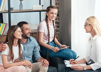 Individual at a table using a notebook , with a laptop placed next to them