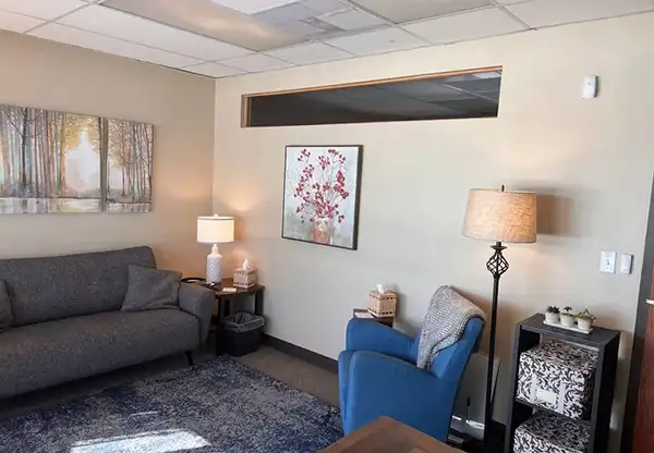 A woman writes notes on a whiteboard, focused and engaged in her task.